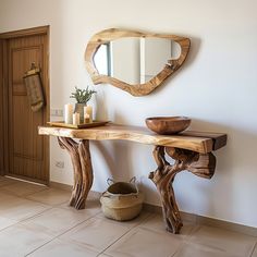 a wooden table sitting next to a mirror and vase on top of a tiled floor