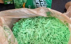 a bag filled with green sprinkles sitting on top of a table