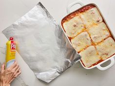 a pan filled with lasagna next to a can of pasta