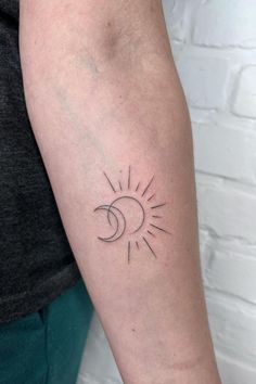 a person with a sun and moon tattoo on their arm