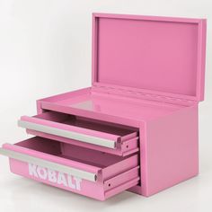 a pink kobalt toy chest with three drawers and the lid opened to reveal it's contents