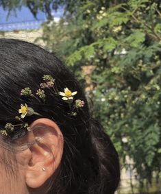 a close up of a person's ear with flowers in the middle of it