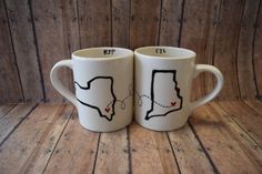 two coffee mugs with the shape of texas on them are sitting side by side