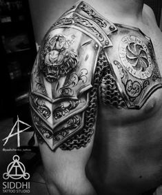 black and white photo of a man's chest with armor tattoos on his arm