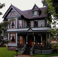 an old photo of a victorian house with red shutters