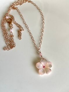 "The cutest little sakura blossom - pink mother of pearl affixed with a tiny pink tourmaline center - is suspended with rose gold-filled wire and dangles from a rose gold-filled cable chain.  Tiny pink opal rondelles frame the wire-wrapping, at the pendant and trigger clasp; necklace measures 17.5\" with a 2\" extender, please select for different length.  Choose between 14K rose gold-filled, sterling silver, or 14K yellow gold-filled metal. Your jewelry will come gift-boxed, and gift-wrapping i Delicate Pink Gold Pendant Jewelry, Dainty Rose Quartz Jewelry In Rose Gold, Delicate Flower Shaped Pink Gold Jewelry, Delicate Pink Gold Flower Jewelry, Dainty Pink Gold Flower Jewelry, Delicate Rose Gold Jewelry With Flower Charm, Delicate Rose Gold Flower Jewelry, Handmade Feminine Rose Gold Jewelry, Pink Gold Flower Jewelry For Gifts