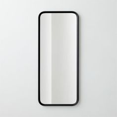 an empty mirror on the wall next to a white wall with a black border around it