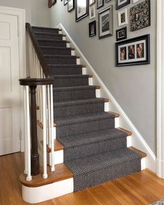 a staircase with pictures on the wall and carpeted steps leading up to the second floor