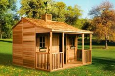 a small wooden shed sitting on top of a lush green field