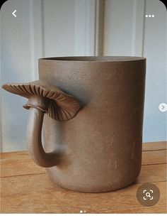 a ceramic coffee cup with a leaf shaped handle