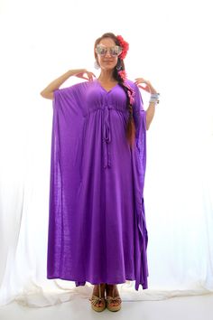 "Summer travel is a breeze when your go-to dress is a maxi kaftan in super soft, rayon jersey knit fabric. Add metallic sandals and sparkly jewelry to get glam in a snap, or try it with earthy accessories for the perfect bohemian summer look. Subtle side slits from the knee down, keep movement in this kaftan easy and the fabric flowing. Available in a rainbow of colors. Shown in \"Cosmic Purple (new color!)\". Fit: -Available in sizes: S ( 2-4), M (6-8), L (10-12) , XL (14-16) , XXL (18-20) See Caftan Dresses, Iris Purple, Purple Jersey, Beach Caftan, Maxi Kaftan, Kaftan Maxi Dress, Get Glam, Bohemian Summer, Maxi Robes