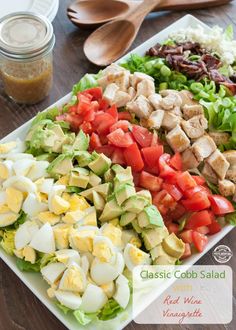 a salad with hard boiled eggs, lettuce, tomatoes and chicken on it