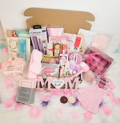 a box filled with lots of items on top of a white fur covered floor next to pink flowers