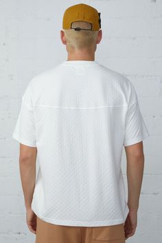 This boxy tee is crafted from jacquard checkered fabric, giving it a unique and stylish look. With a back yoke design, this tee offers a comfortable and flattering fit for any occasion. 96% Cotton 4% Spandex Models are 6'2" and wearing a size medium White Jacquard Knit Short Sleeve Top, Summer Jacquard Knit Crew Neck Top, Casual Short Sleeve Textured Top, Casual Textured Short Sleeve Top, White Jacquard Knit Crew Neck Tops, Relaxed Fit Textured Crew Neck Top, Casual Textured Crew Neck Top, Textured Relaxed Fit Crew Neck Top, Textured Crew Neck Casual Tops