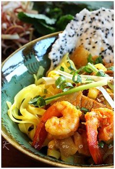 a close up of a plate of food with shrimp and noodles on it, next to rice