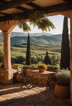 an outdoor table and chairs on a patio with mountains in the background