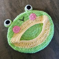 a crocheted frog hat with eyes on it