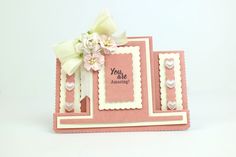 a pink and white card with flowers on it