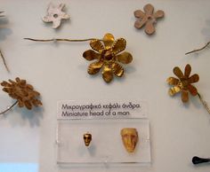 there are many decorative objects on display in the museum's glass case, including gold and silver brooches