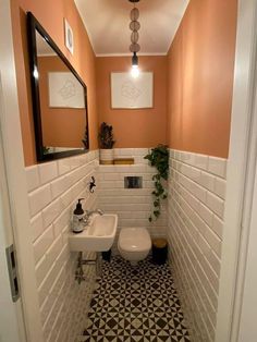 a bathroom with orange walls and black and white flooring