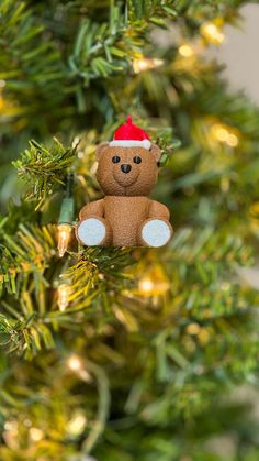 a brown teddy bear sitting on top of a christmas tree