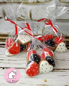 heart shaped cookies wrapped in cellophane and tied with red ribbon on white wooden table