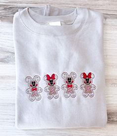 three embroidered mickey mouses sitting next to each other on a white shirt with red bows