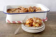 a casserole dish filled with food next to a fork on a wooden table