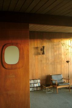 a room with wood paneling and a chair