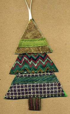 a christmas tree made out of fabric on top of a piece of cardboard with a fork sticking out of it