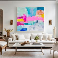 a living room filled with furniture and a large painting on the wall above it's coffee table