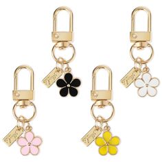 three key chains with flowers on them and two charms attached to each other, both in different colors