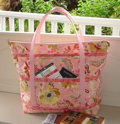 a pink bag with flowers on it and a passport in the pocket is sitting outside