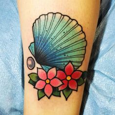 a tattoo with a shell and flowers on it