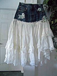 a white skirt hanging from a door with flowers on the bottom and an old pair of jeans underneath it