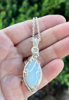 This diamond shaped opalite pendant is wrapped in silver wire and adorned with silver beads and a beautiful swirl on top. Handmade jewelry is one of the best gifts! Opalite is deigned to mimic the October birthstone, natural opal, so this would be the perfect gift for those you know born in October. The pendant comes with a complimentary chain. Opalite Jewelry, Born In October, Diy Wire Jewelry, October Birthstone, Diamond Shaped, Natural Opal, October Birth Stone, Silver Wire, Wire Jewelry