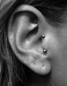 a woman's ear is shown with two piercings