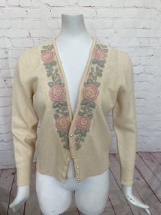 "Retro womens Evan Picone cardigan Pale pastel yellow sweater is nicely embroidered with light pink and green flowers and leaves Pearl buttons Excellent vintage condition. Slight hole at bottom front by side seam, hardly noticeable. See photo #6 (ribbed waist area) Tag size Medium 95% Lambswool 5% Nylon Measurements when laying flat across: Bust - 20\" Sleeve length - 21\" Length - 22.5\" Waist - 15\"" Vintage Cream Sweater For Spring, Fitted Embroidered Beige Sweater, Vintage Spring Sweater With Buttons, Fitted Cream Embroidered Sweater, Spring Embroidered White Cardigan, Fitted Cream Sweater With Floral Embroidery, Vintage Embroidered Sweater For Spring, Cream Embroidered Fitted Sweater, Vintage Beige Embroidered Sweater