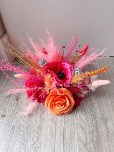 an arrangement of flowers and feathers on the floor