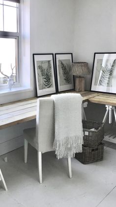 a room with three framed pictures on the wall and a bench in front of it