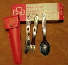 four forks and two spoons are sitting next to a red case