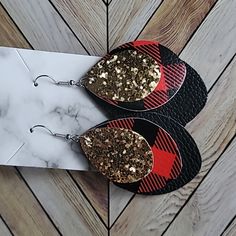 two red and black earrings with gold flecks sitting on top of each other