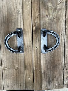 an old door with two metal handles on the front and back doors are locked to wood planks