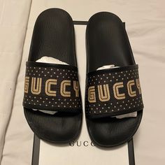 Brand New Gucci Sandals From The Guccy Collection. Black Rubber And Gold. Gucci Designer Open Toe Slides, Luxury Black Beach Slides, Luxury Black Slides For Beach, Luxury Black Slides For The Beach, Gucci Luxury Beach Sandals, Luxury Black Flat Slides, Black Luxury Flat Slides, Designer Black Open Toe Slides, Designer Gucci Slides