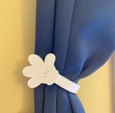 a close up of a blue curtain with a white flower on the back of it