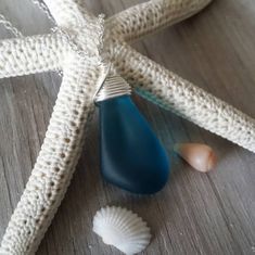 a starfish with two seashells and a blue glass pendant