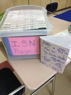 there is a desk with several books on it and a plastic container that has writing on it