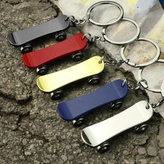 four different colored metal key chains on the ground