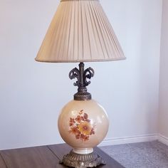 a lamp that is sitting on top of a wooden table next to a white wall