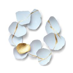 four white and gold paper flowers on a white background with golden foiled petals in the center